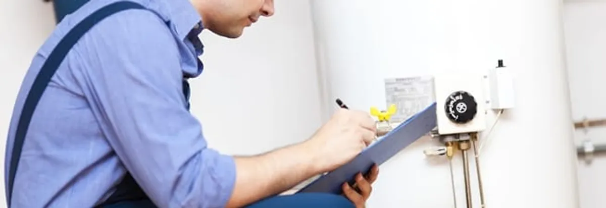 Water heater repair technician inspecting the unit and recording service notes in Overland Park, KS